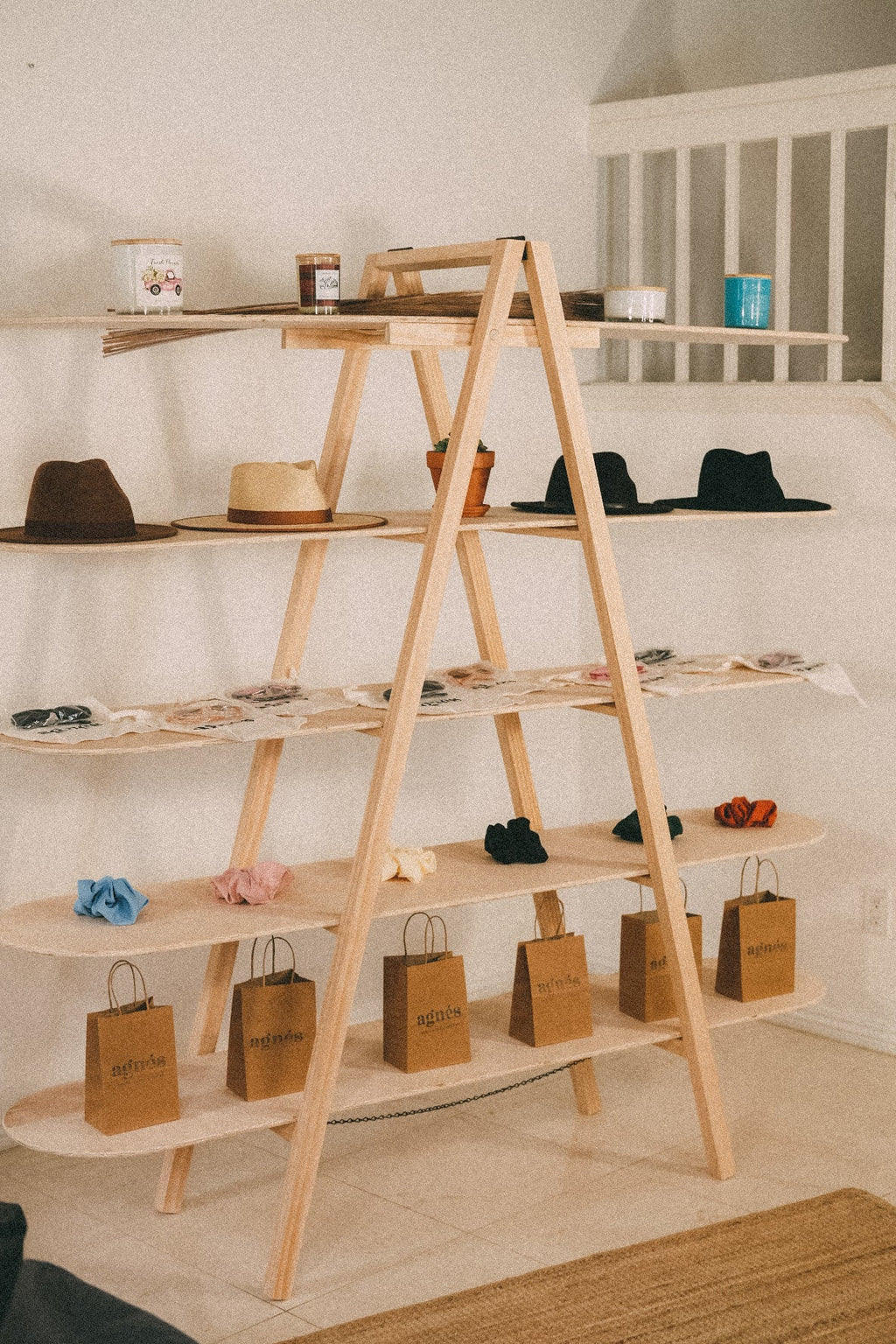 STANDRO LSD-5 five-tier wooden A-frame display shelving with hats, accessories and paper bags for a pop-up shop.