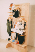 STANDRO PB-1 freestanding wooden pegboard display with swimwear on hangers, three shelves and small accessories.