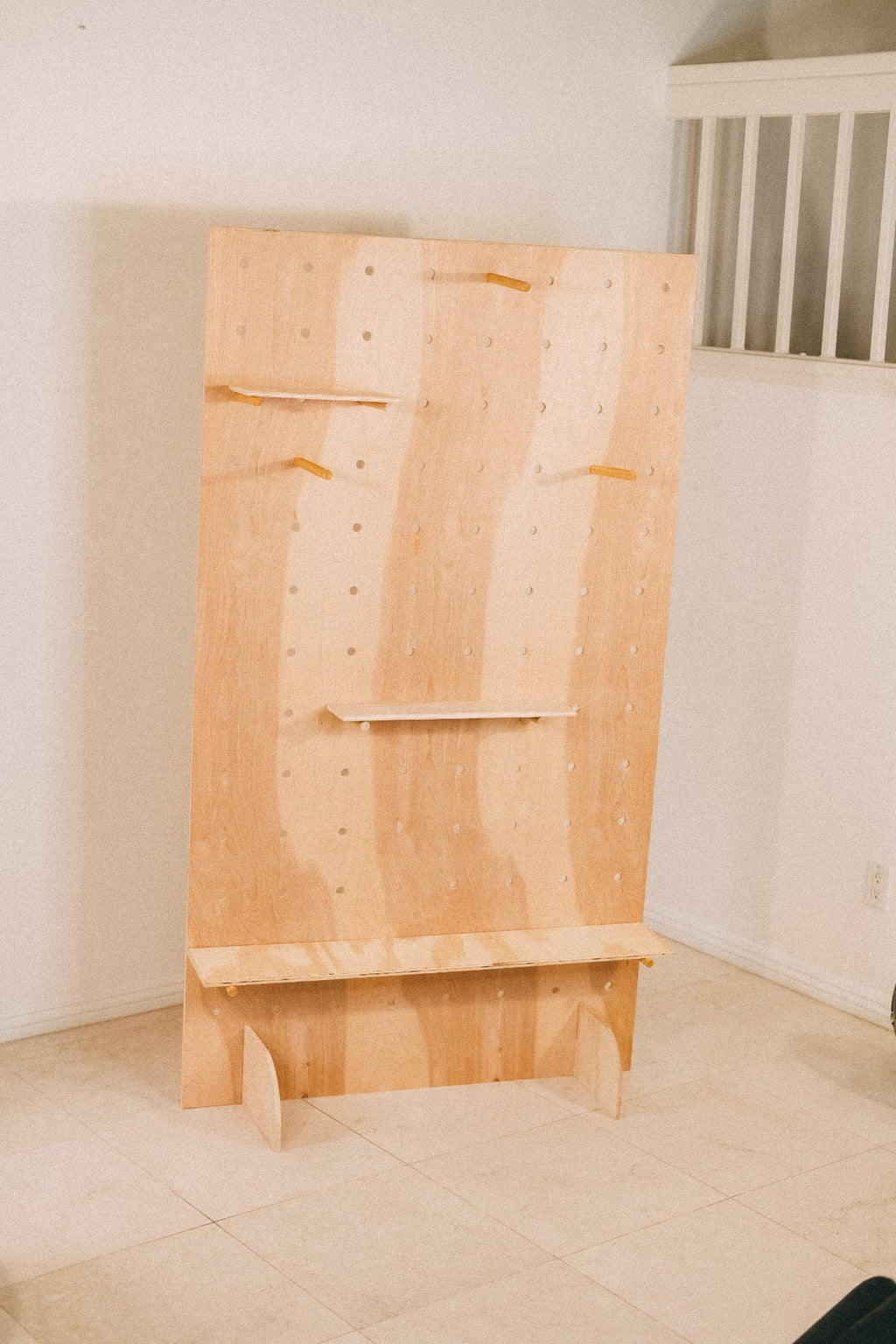 Empty PB-1 wooden pegboard with three display shelves, projecting pegs and two curved base supports.
