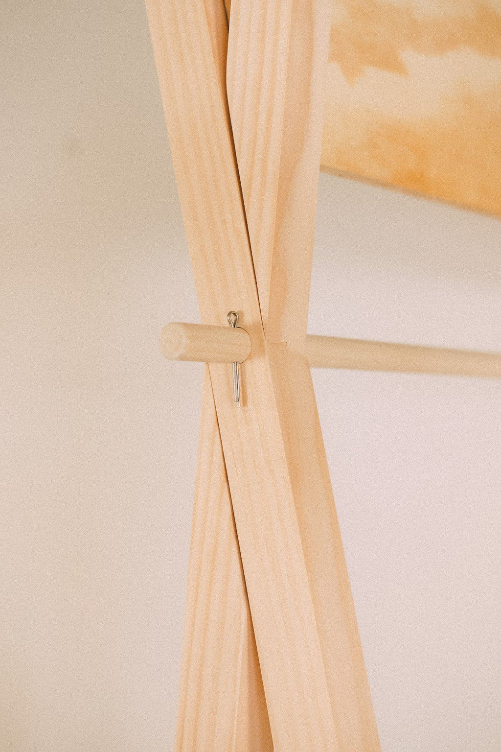 Side detail of the display's upper wooden frame, with a projecting pin and hanging rail below the header board.