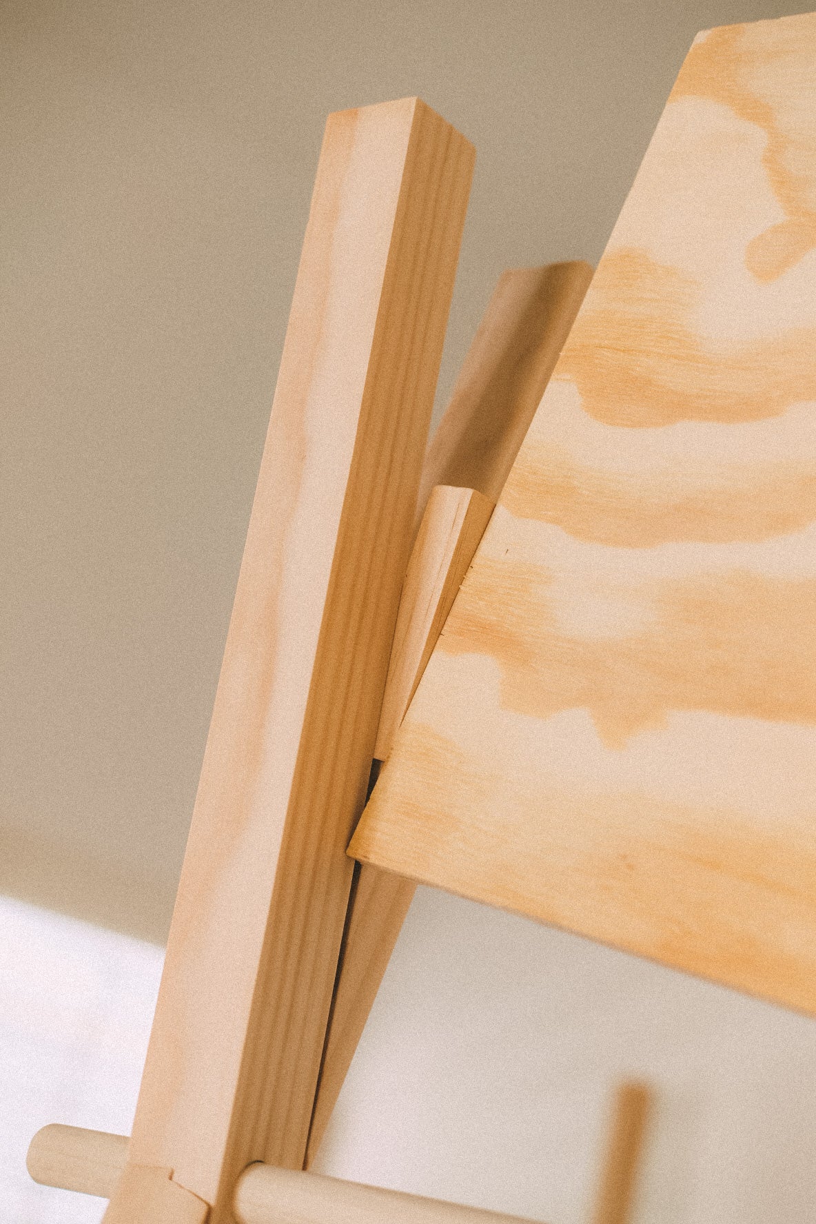 Close-up of a plywood header board seated between wooden uprights, showing the board edge and wood grain.