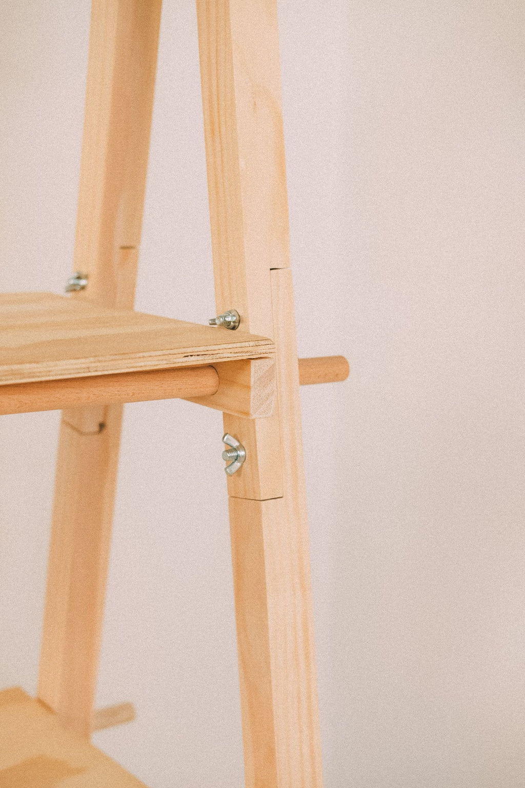 Side detail of a wooden shelf joined to the A-frame, showing a projecting pin and metal fasteners.