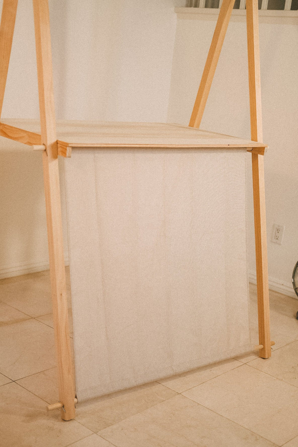 Empty wooden market counter viewed at an angle, showing the tabletop, solid front panel and side supports.