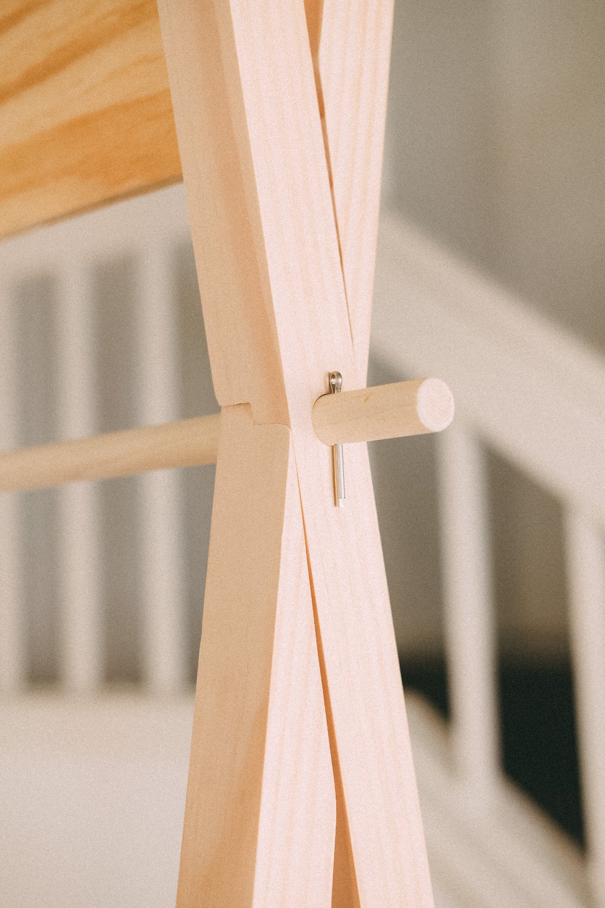 Close-up of crossed wooden frame members joined around a projecting cylindrical wooden pin.