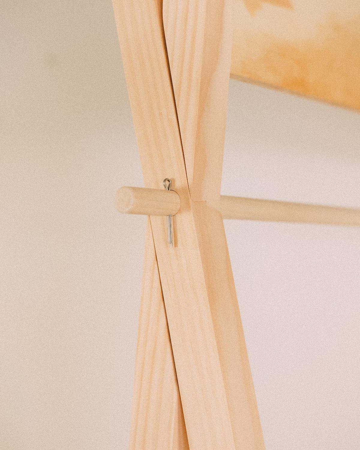 Close-up of crossed timber frame members, a projecting wooden pin and the display's horizontal rail.
