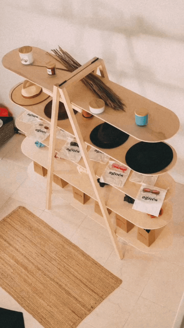 Slideshow of a stocked wooden A-frame display, with overall views and close-ups of hats and packaged accessories.