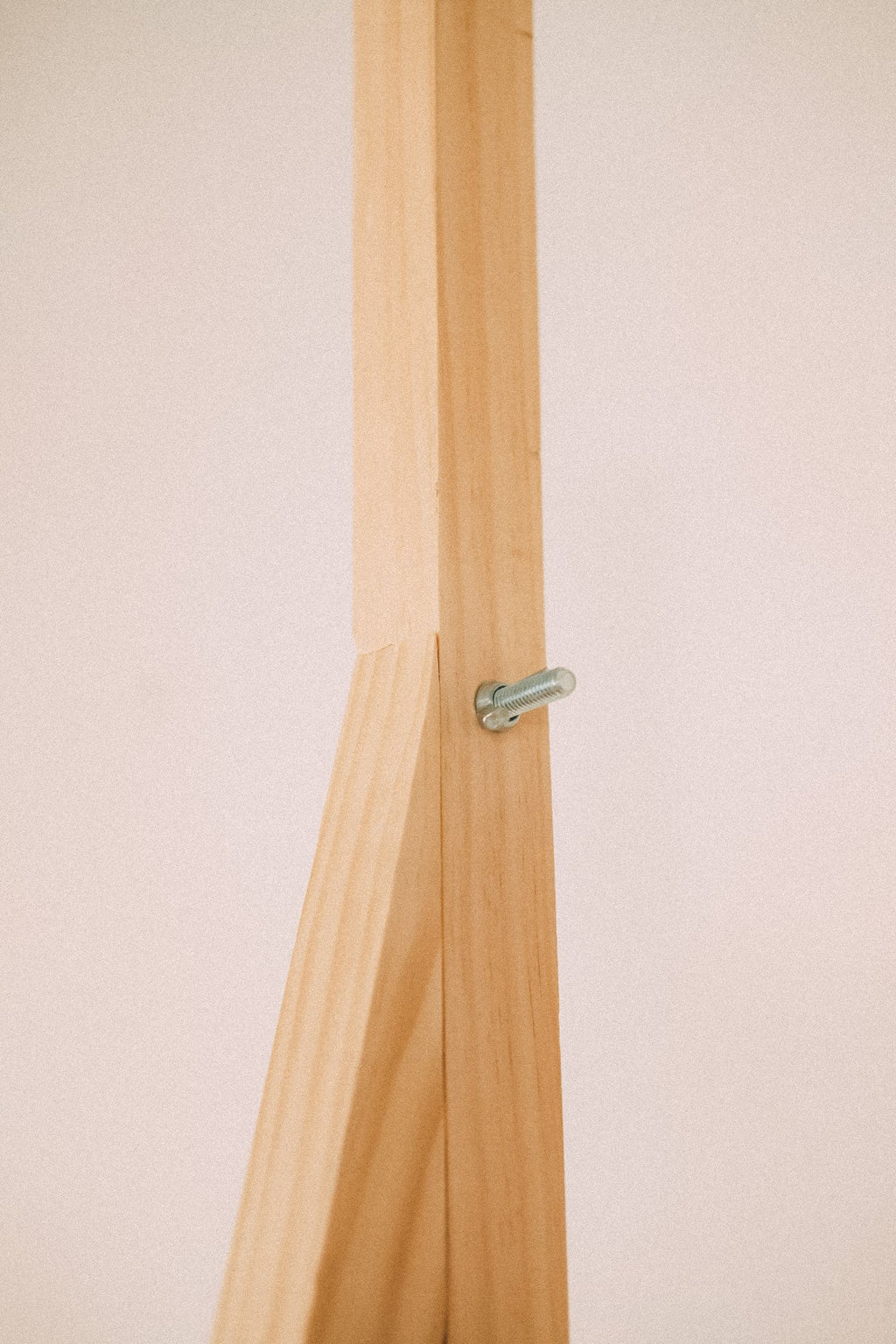 Close-up of a timber frame connection secured by a metal retaining clip on the wooden market display.