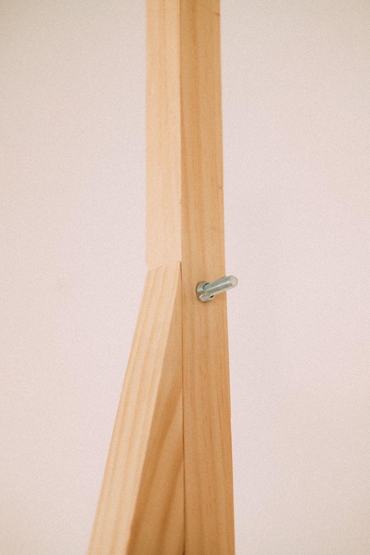 Close-up of a timber frame connection secured by a metal retaining clip on the wooden market display.