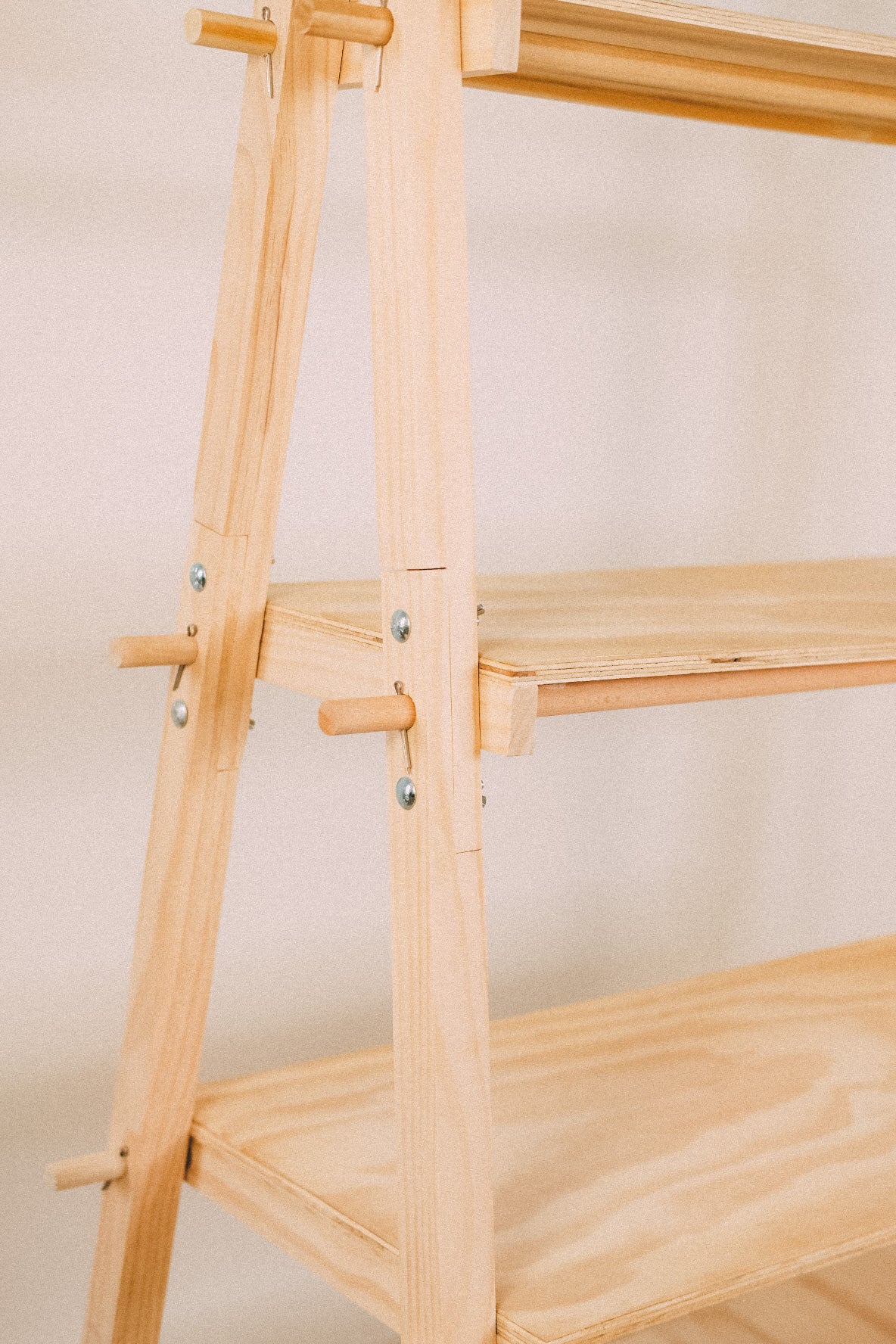 Close-up of wooden display shelves meeting the timber frame, with projecting pins and visible metal fasteners.